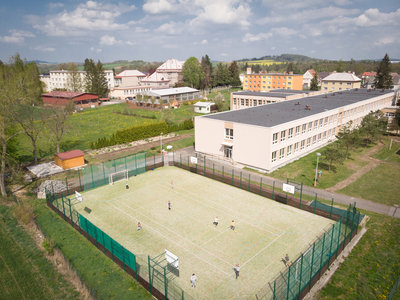 Pohled z dornu - hřiště s umělou plochou a zahrada školy.