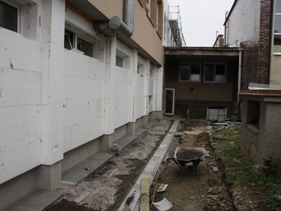 Budování nového opláštění a práce na novém chodníčku - zadní vchod. 